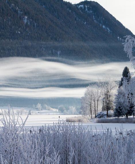 Blick vom Hotel Lacus auf den zugefrorenen Weissensee im Winter