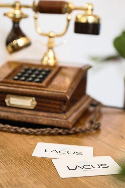 Vintage-Telefon auf Holztisch mit zwei LACUS Hotelkarten im Vordergrund