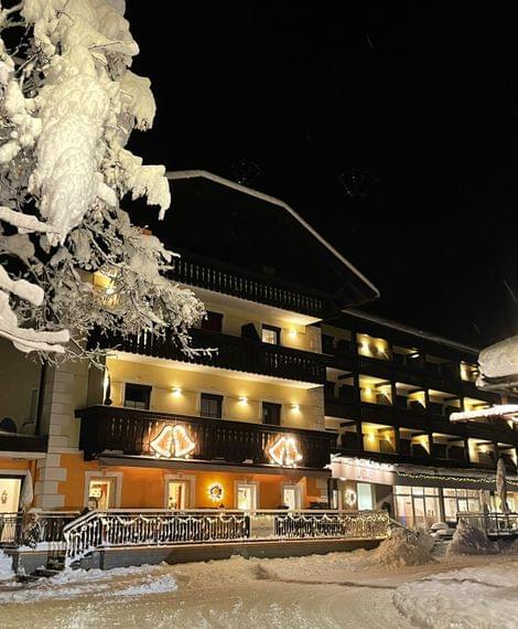 Beleuchtetes Hotel im verschneiten Teffendorf bei Nacht mit winterlicher Dekoration